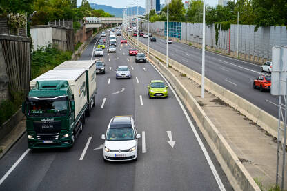 Automobili i kamioni na autoputu. Automobili i kamioni se kreću autoputem u Austriji. Vozila u pokretu. Vožnja automobilom na autoputu. Kretanje automobila, autobusa i kamiona po autoputu. Prijevoz. Transport. Cestovni saobraćaj