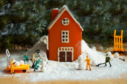 Iustracija sa kućicom i figuricama radnika koji prave grudve i snješka od snijega.