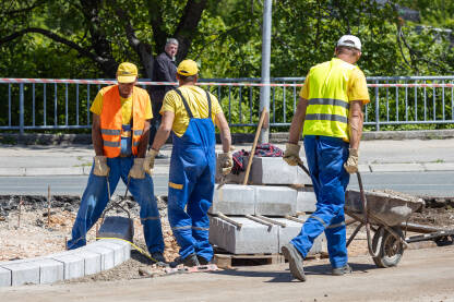 Građevinski radnici na gradilištu, u zaštitnoj opremi.