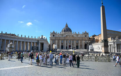 Vatikan: Ljudi na Trgu svetog Petra. Bazilika Svetog Petra. Turisti istražuju Rim i Vatikan.