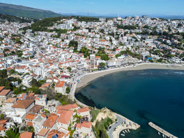 Ulcinj, Crna Gora, panorama grada. Zgrade uz plažu. Ulcinj, Crna Gora, 11. april 2025: Zgrade i kuće uz obalu, snimak dronom. Popularna turistička destinacija. Pješčana plaža u gradu.
