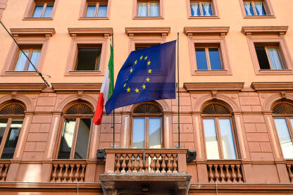 Zastava Italije i Evropske unije Italijanska i zastava EU vijore se na vjetru. Zastava Italije i Evropske unije na jarbolu. Simbol Italije i EU.