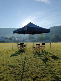 Snimanje filma. Redateljske stolice ispod šatora na nogometnom terenu
