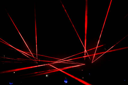 Laserska svjetla na koncertu. Laserska svjetla na koncertu. Crvena laserska svjetla na bini noću. Apstraktna pozadina. Laserski snop.