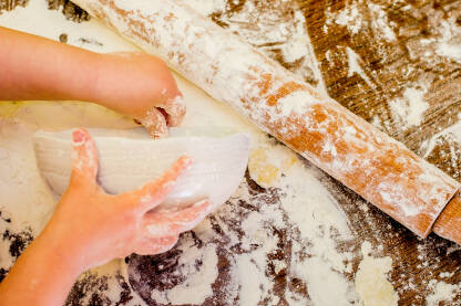 Childrens hands preparing dough for cookies IV Dječije ruke pripremaju tijesto za kolače