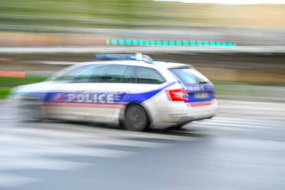 Policijsko patrolno vozilo se brzo kreće ulicom. Zamućena policijsko patrolno vozilo se brzo kreće ulicom u Parizu, Francuska. Bočni pogled na policijski automobil s natpisom "Police".