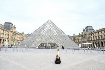 Ljudi ispred muzeja Louvre u Parizu Pariz, Francuska: Ljudi ispred muzeja Louvre. Staklene piramide ispred poznatog muzeja. Turisti istražuju grad.