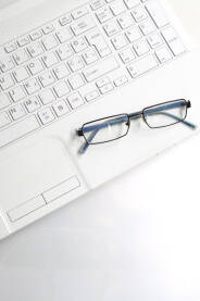 Bijeli laptop na bijeloj podlozi Bijeli laptop na bijeloj podlozi sa naocalama.