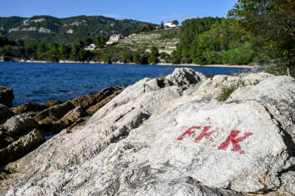 FKK znak na plaži. Nudistička plaža. FKK znak na plaži. Znak naturizma. Nudistička plaža uz more.
