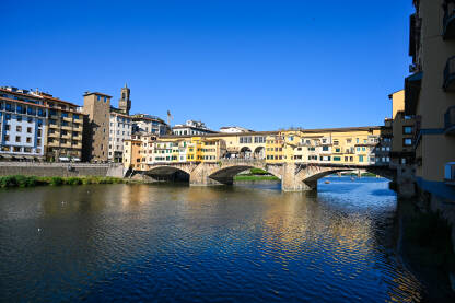 Firenze, Italija: most Vecchio preko rijeke Arno. Firenze, Italija: most Vecchio preko rijeke Arno. Historijske građevine uz rijeku. Popularno turističko odredište.
