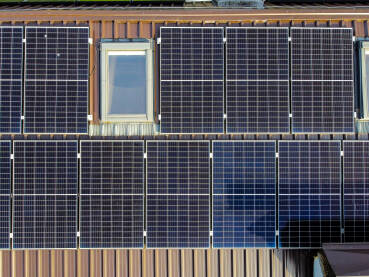 Solarne ploče na vrhu zgrade Solarne ploče na vrhu zgrade, snimak dronom. Proizvodnja električne energije. Solarni paneli na kući. Proizvodnja čiste obnovljive energije od sunca. Fotonaponske solarne ćelije.