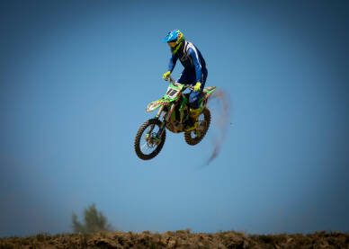 Motocross utrka Motorista u skoku. Vozač cross motora tokom trke. Motocross trka. Takmičenje u vožnji cross motora.