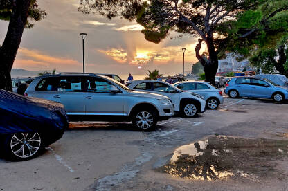 Zalazak sunca na parkingu pored obale mora.