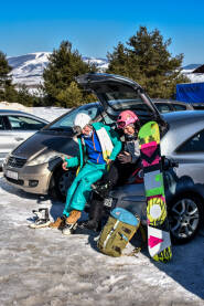 Spremanje za stazu Djevojke se spremaju za ski stazu. Oblačenje ski opreme na parkingu u gepeku. Skijalište Kupres.
