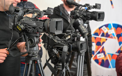 Kamere na konferenciji za novinare Kamere na konferenciji za novinare. Snimanje press događaja video kamerom. Novinarstvo. Profesionalni snimatelj kamerom snima intervju.