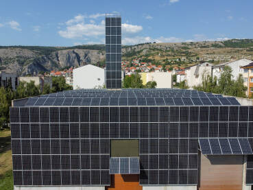 Solarni paneli na krovu. Solarni paneli na krovu objekta. Snimak dronom na solarne panele na vrhu zgrade. Proizvodnja čiste obnovljive energije iz sunca. Fotonaponske solarne ćelije. Električna energija.