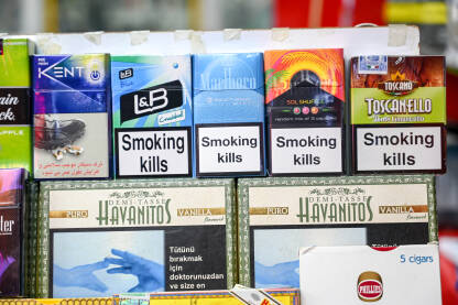 Kutije cigareta na policama u supermarketu. Kutije cigareta na policama u supermarketu. Kutije cigara sa upozorenjima. Duhan. Natpisi: Pušenje ubija.
