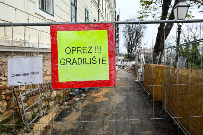 Znak "oprez gradilište" u blizini gradilišta. Znak "oprez gradilište" na ogradi u blizini gradilišta. Znak: "Zabranjen prolaz".