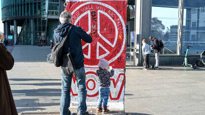 AK1_0606 Berlin, Njemačka: Očuvani dio Berlinskog zida. Ostaci originalnog Berlinskog zida sa znakom mira na njemu. Popularna turistička destinacija.