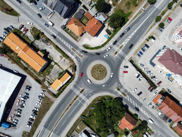 Kružni tok u gradu, snimak dronom. Kružni tok u gradu, snimak dronom. Automobili se kreću na asfaltnom putu. Saobraćaj na kružnom toku u gradu. Saobraćaj.