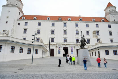 Bratislava, Slovačka. Dvorac iznad starog grada. Turisti. Bratislava, Slovačka. Dvorac na brdu iznad starog grada. Turisti fotografišu dvorac. Popularna turistička destinacija. Spomenik.
