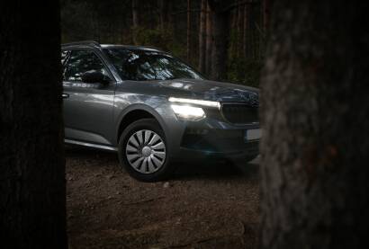 Automobil škoda u šumi Škoda parkirana između stabala s upaljenim svijetlima