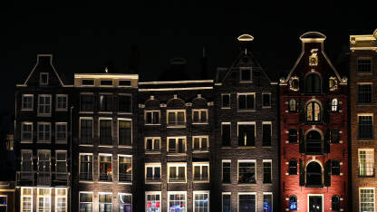 Amsterdam, Holandija Amsterdam, Holandija. Tradicionalne kuće u gradu Amsterdamu noću. Tipične holandske kuće sa šarenim fasadama.