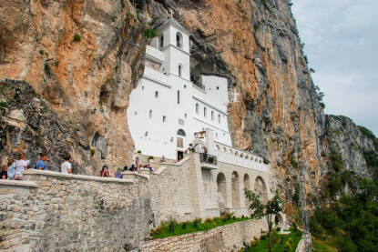 Manastir Ostrog, Crna Gora. Manastir Ostrog, Crna Gora. Vjernici u posjeti manastiru. Hodočasnici. Pravoslavni manastir je smješten u stijenama na 900 metara nadmorske visine između Podgorice i Nikšića.