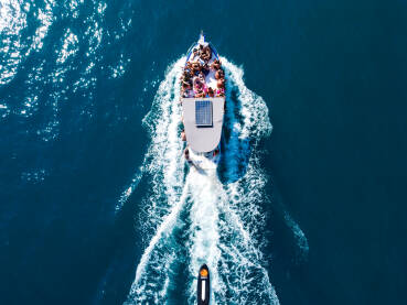 Grupa ljudi putuje turističkim brodom. Brod na moru, snimak dronom. Turistički brod plovi morem.