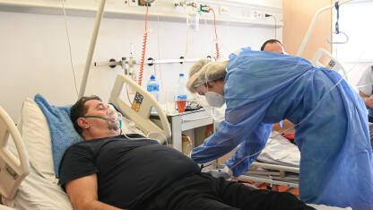 Čovjek na respiratoru Čovjek na respiratoru u bolnici. Medicinska sestra s pacijentom zaraženim koronavirusom leži u klinici. Pacijent sa COVID-om leži u bolničkom krevetu na respiratoru.