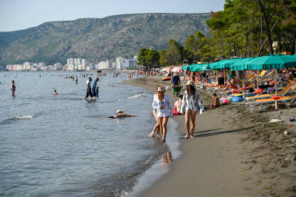 Shëngjin, Albanija, Popularna turistička destinacija. Shëngjin, Albanija. Ljudi plivaju u moru i sunčaju se na plaži. Turisti na ljetnom godišnjem odmori. Popularna turistička destinacija na Jadranskom moru u Albaniji.