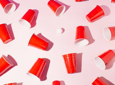 Crvene plastične čaše Crvene plastične čaše za beer pong na roze pozadini.