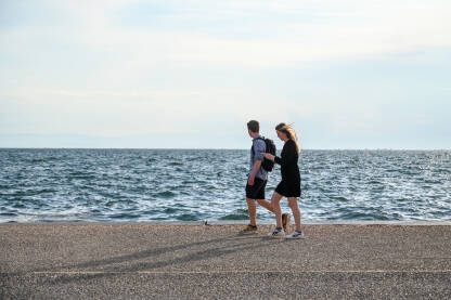 Ljudi šetaju šetalištem uz more. Thessaloniki, Grčka: Ljudi šetaju šetalištem uz more. Turisti u gradu.