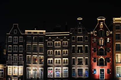 Amsterdam, Nizozemska Amsterdam, Nizozemska. Popularne zgrade u gradu Amsterdamu noću. Tipične holandske kuće sa šarenim fasadama. Holandija
