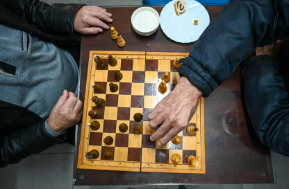 Stariji ljudi igraju šah. Partija šaha. Stariji ljudi igraju šah. Partija šaha. Šahovska ploča i figure na stolu. Muškarci igraju šah. Šahisti.