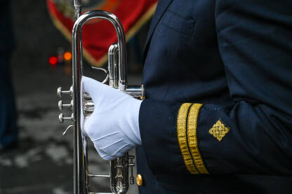 Muzičar sa trubom Muzičar sa trubom. Vojnik u bijelim rukavicama svira trubu. Vojni orkestar na paradi.
