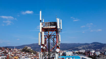 GSM i radio telekomunikacioni toranj u gradu. GSM i radio telekomunikacioni toranj u gradu. Toranj mobilnih telefona, snimak dronom. Bazna primopredajna stanica. Bežični komunikacioni antenski predajnik.