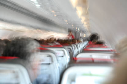 Turbulencija u avionu. Putnici u kabini. Turbulencija u avionu. Putnici u kabini tokom turbulentnog leta. Zamućena fotografija u avionu. Putovanje avionom. Strah od letenja.