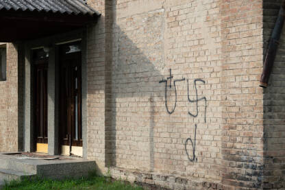 Fašistički simboli, kukasti krst i ustaški grb Grafiti fašističkih simbola na zidu u Brodu