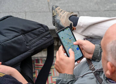 Čovjek koristi mapu na telefonu. Čovjek koristi mapu na svom mobilnom telefonu. Turisti koriste Google mape na pametnom telefonu za orijentaciju. Čovjek koji istražuje grad.