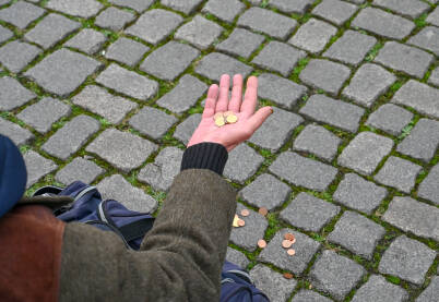 Siromah prosi novac. Ruka starca drži kovanice. Gladan beskućnik traži novac. Siromaštvo.