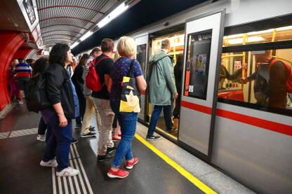 Putnici na stanici podzemne željeznice. Beč, Austrija: Putnici na stanici podzemne željeznice. Voz na stanici. Željeznica. Javni prijevoz. Ljudi ulaze i izlaze iz metroa.