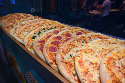 Ukusna pizza servirana u restoranu. Ukusna pizza servirana u restoranu. Brza hrana. Mnogo različitih vrsta italijanskih pizza na stolu.