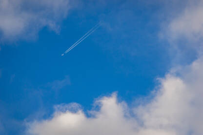 bright blue sky with clouds and airplane trail Svijetlo plavo nebo sa oblacima i tragom aviona