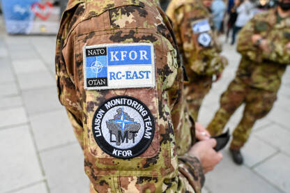 NATO i KFOR oznaka na ramenu vojnika. NATO i KFOR oznaka na ramenu vojnika. KFOR snage su međunarodne mirovne snage predvođene NATO-om. Vojnici KFOR-a u Prištini, Kosovo. Amblem.