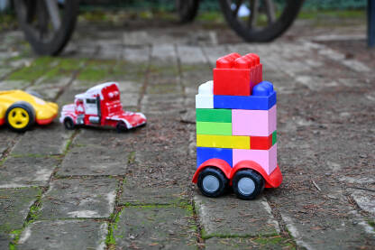 Dječje igračke u dvorištu. Autići i kockice slagalice.