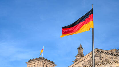 Njemačka zastava Njemačka zastava vijori na vjetru. Zastavu Njemačke na jarbolu ispred Bundestaga u Berlinu.