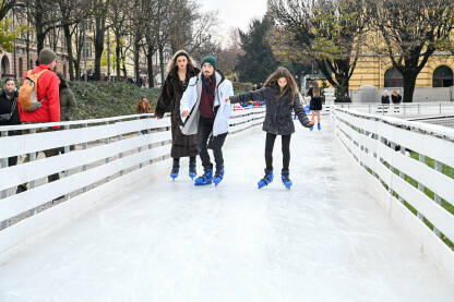 Ljudi se kližu na ledu. Mladi ljudi na klizaljkama. Advent u Zagrebu, Hrvatska.