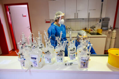 Medicinske sestre i infuzije Medicinski radnici sa maskama za lice tokom pandemije koronavirusa. Medicinske sestre sa maskama u bolnici. Covid-19. Infuzije na stolu.