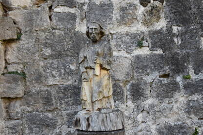 Drveni čovjek, Jajce Drvena statua čovjeka sa kamenim zidom koji se nalazi u pozadini na tvrđavi u Jajcu.